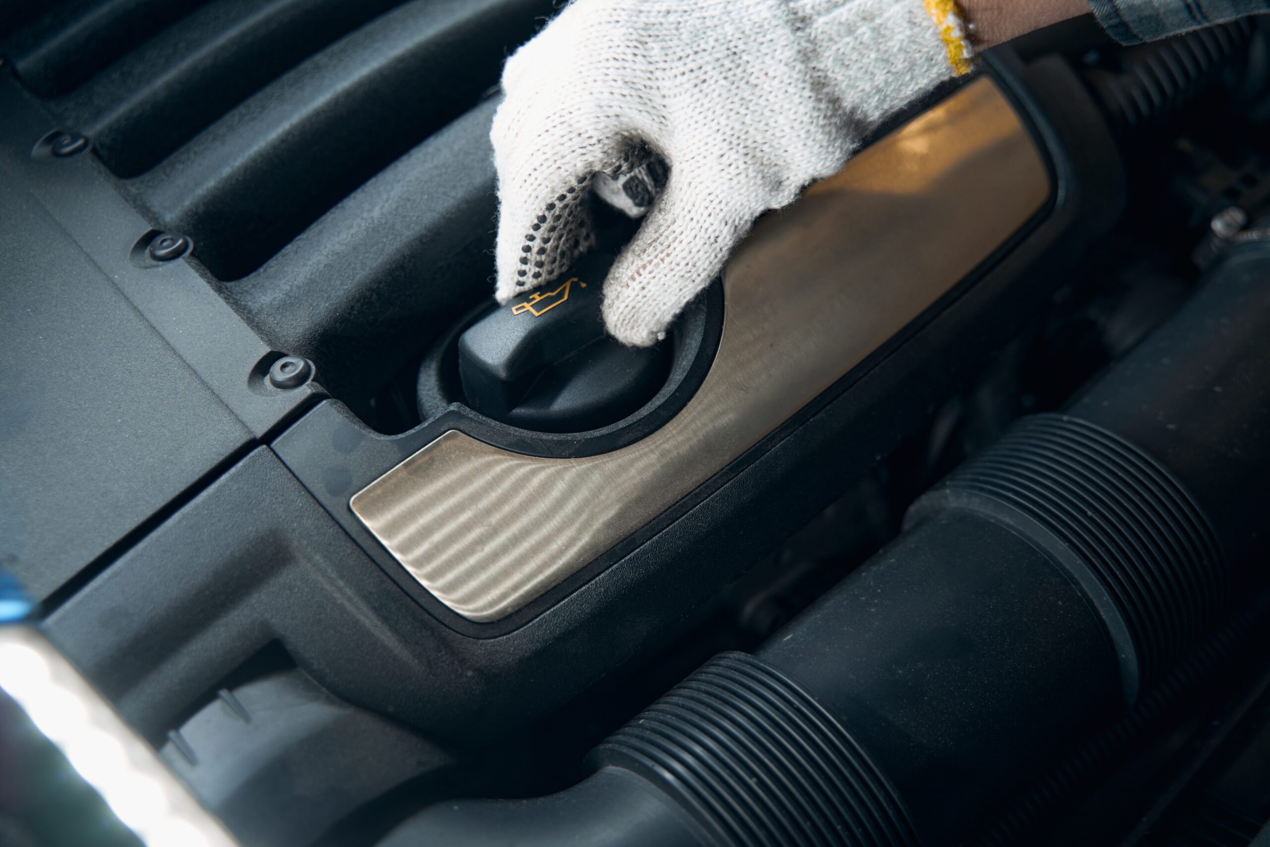 Cropped photo of unrecognised person hand in glove touching the oil pressure warning button in a car